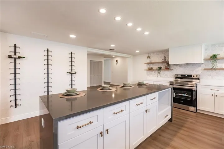 Kitchen featuring range with electric stovetop, white cabinetry, and light hardwood / wood-style flooring