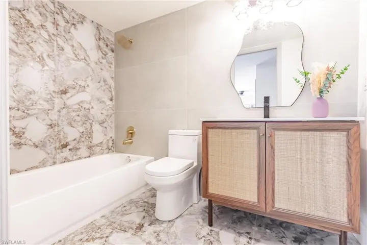 Full bathroom featuring tiled shower / bath combo, sink, toilet, and tile floors