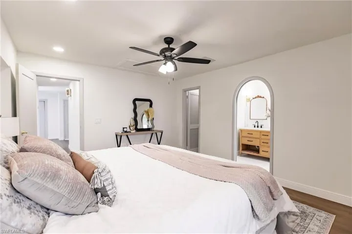 Bedroom featuring hardwood / wood-style floors, ensuite bathroom, sink, and ceiling fan