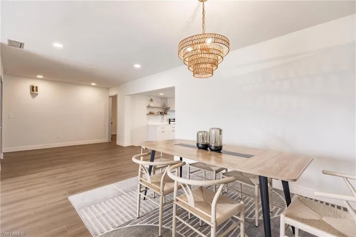 Dining room featuring wood-type flooring and an inviting chandelier