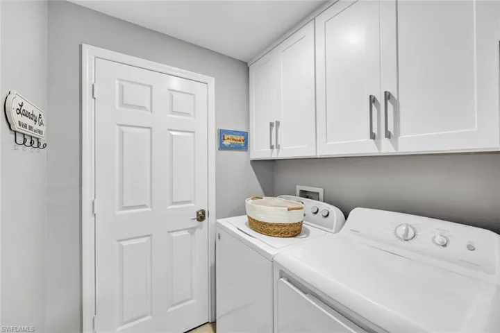 Laundry room with washing machine and clothes dryer and cabinets