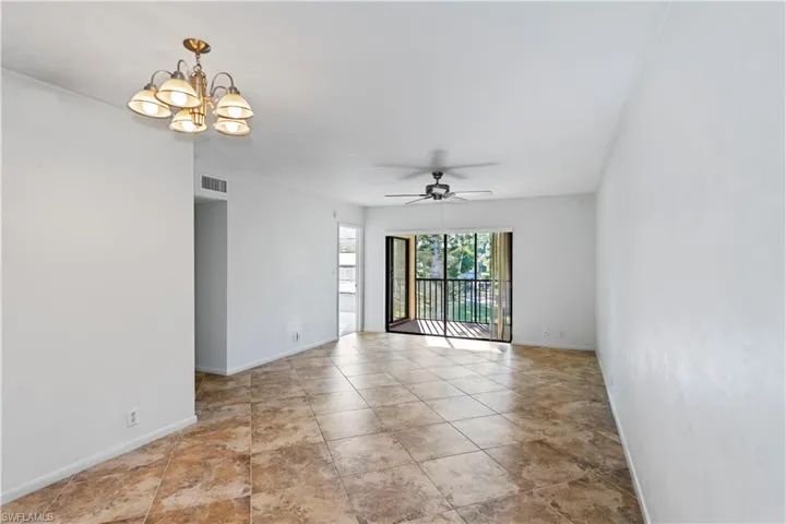 Unfurnished room featuring a chandelier and a ceiling fan