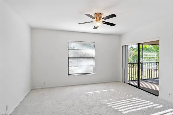 Carpeted spare room with ceiling fan and baseboards