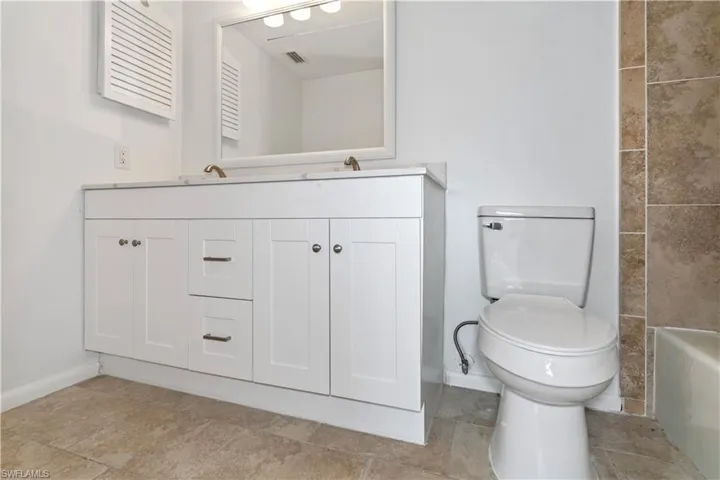 Full bathroom featuring toilet and double vanity