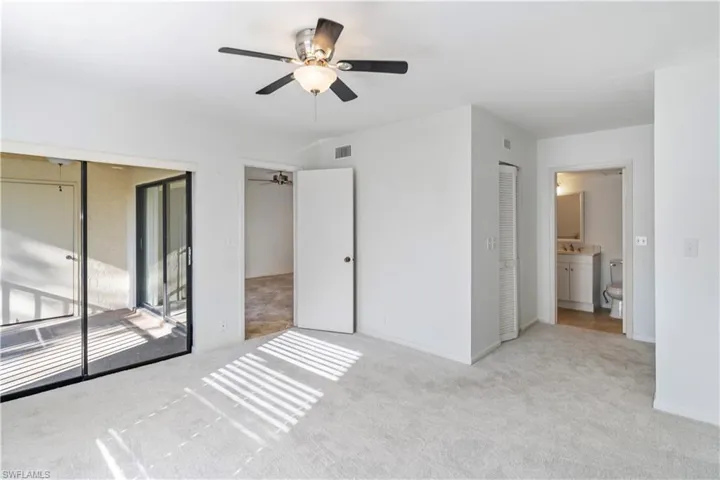 Unfurnished bedroom featuring access to outside, a ceiling fan, carpet flooring, a closet, and connected bathroom