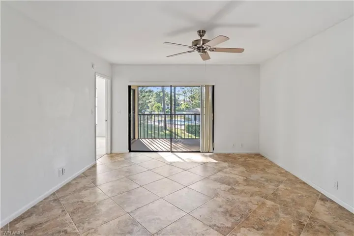 Empty room with a ceiling fan and light tile patterned floors