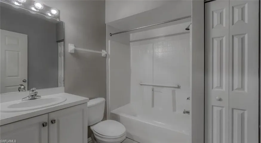 Full bathroom featuring shower / bathing tub combination, vanity, and toilet.  This bathroom is located off kitchen
