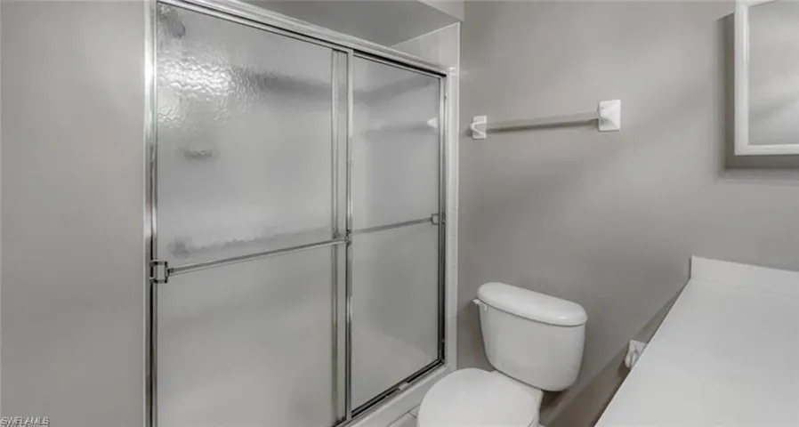 Bathroom with toilet and a shower with door