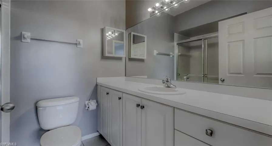 Bathroom featuring vanity, toilet, and walk in shower