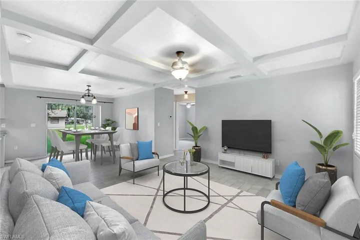 Living area featuring coffered ceiling, beam ceiling, a ceiling fan, light wood-type flooring, and baseboards