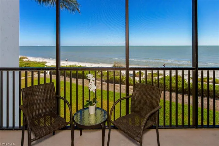 Balcony featuring a beach view and a water view