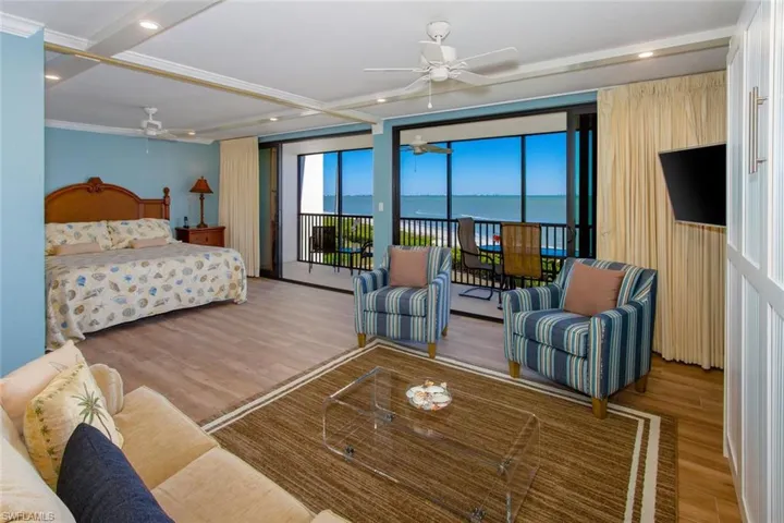 Bedroom with ceiling fan, light hardwood / wood-style floors, crown molding, and access to exterior