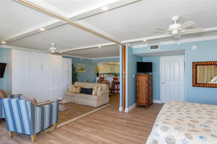 Bedroom with crown molding, light hardwood / wood-style flooring, and ceiling fan
