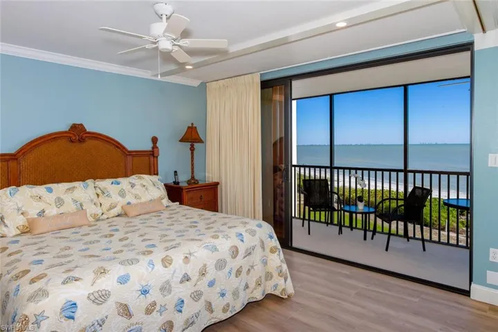 Bedroom with a water view, ornamental molding, access to outside, and light hardwood / wood-style flooring