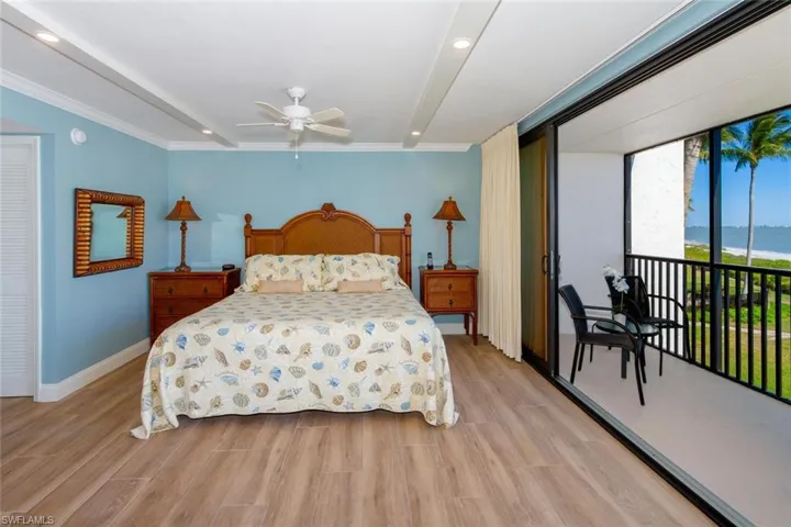 Bedroom with crown molding, light wood-type flooring, a water view, access to outside, and ceiling fan