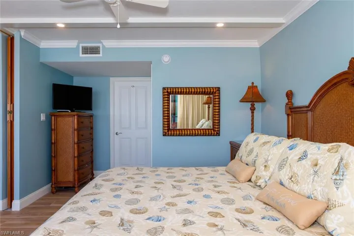 Bedroom featuring ceiling fan, light hardwood / wood-style floors, and ornamental molding