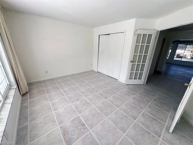 Unfurnished bedroom with tile patterned flooring and a closet