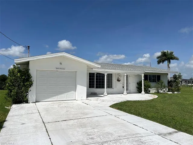 Single story home featuring a garage and a front lawn