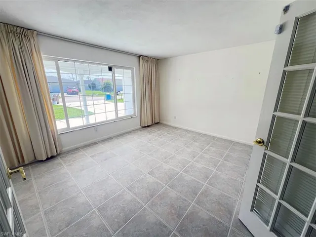 Tiled empty room featuring a textured ceiling