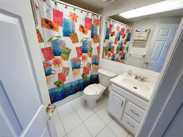 Bathroom featuring vanity, toilet, a shower with curtain, and tile patterned floors