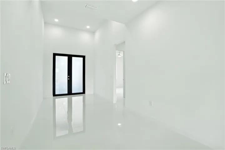 Unfurnished room with recessed lighting and french doors