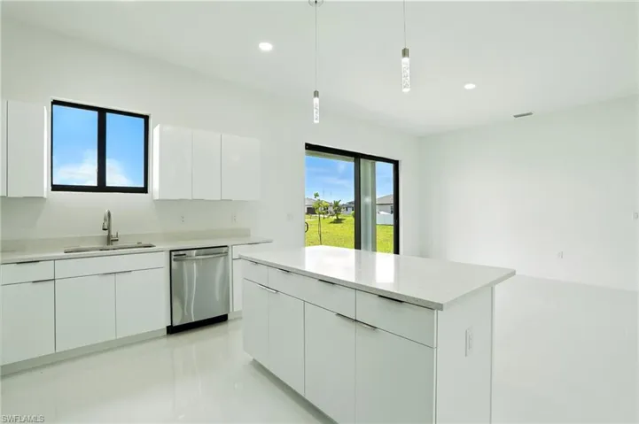 Kitchen featuring modern cabinets, white cabinetry, pendant lighting, stainless steel dishwasher, and recessed lighting