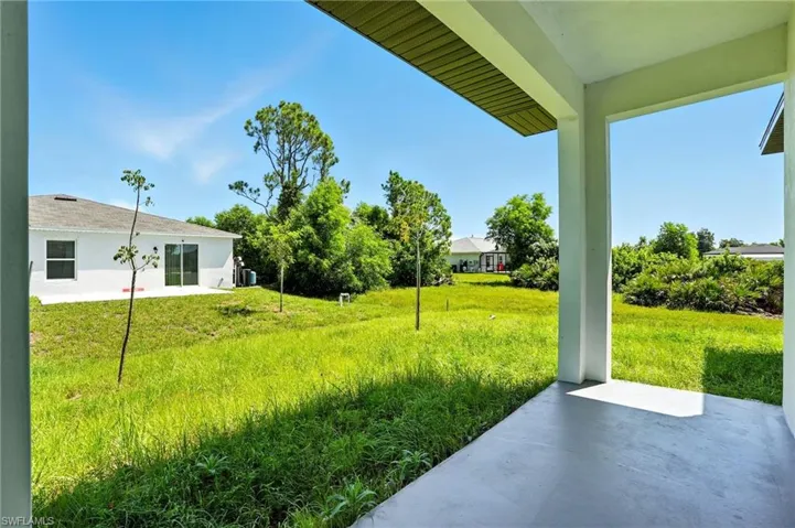 View of grassy yard featuring a patio area