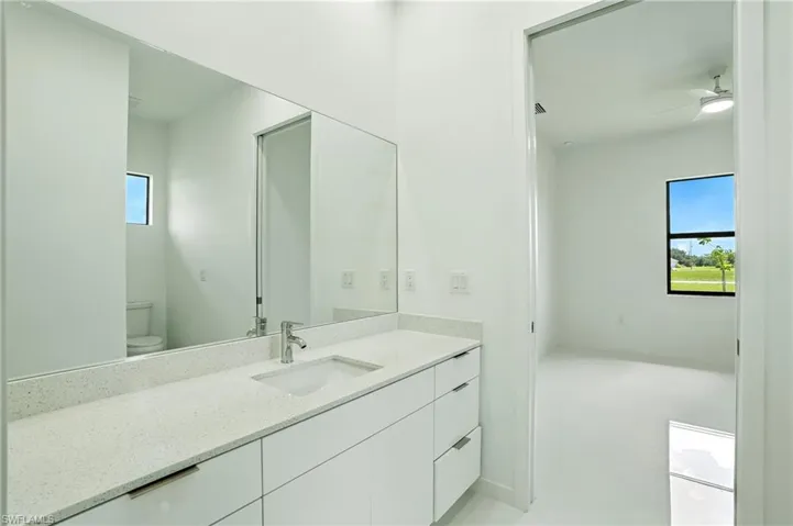 Bathroom with vanity, a ceiling fan, and light tile patterned flooring