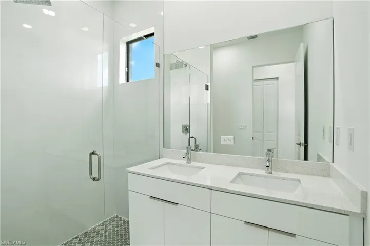 Full bath featuring a stall shower and double vanity