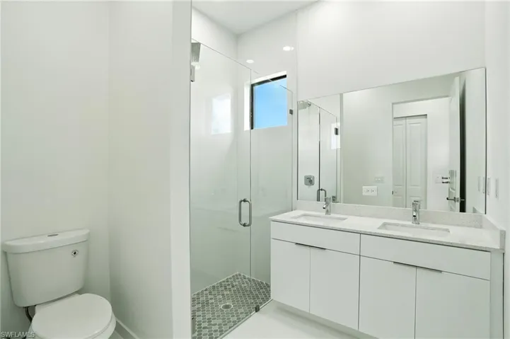Bathroom featuring a stall shower and double vanity