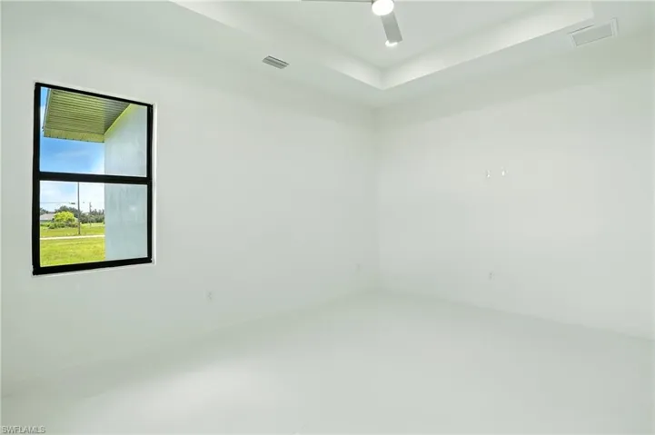 Spare room featuring a tray ceiling and a ceiling fan