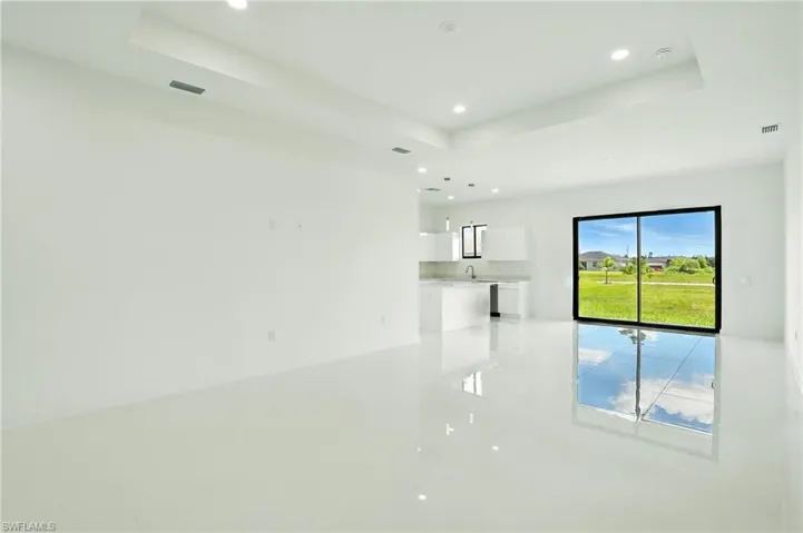 Empty room with a raised ceiling and recessed lighting