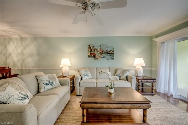 Living area with ornamental molding, ceiling fan, and wood finished floors