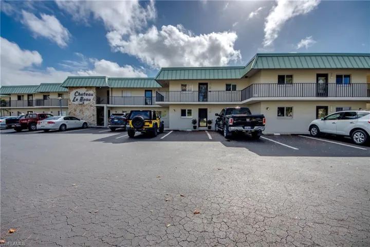 View of building exterior with uncovered parking