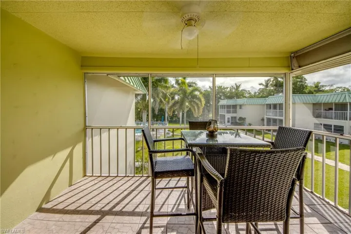 Sunroom / solarium with a balcony and ceiling fan