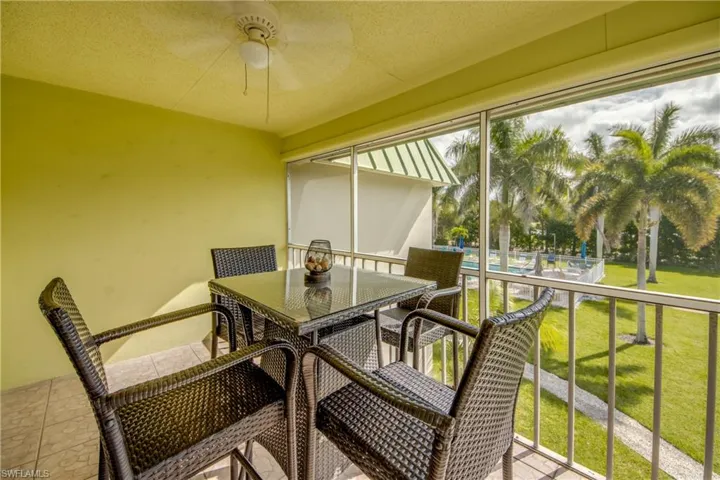 Sunroom featuring outdoor dining space, ceiling fan, and a balcony