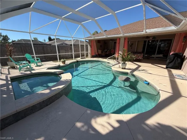 Integrated pool / spa featuring glass enclosure, a patio area, a sunroom, and area for grilling