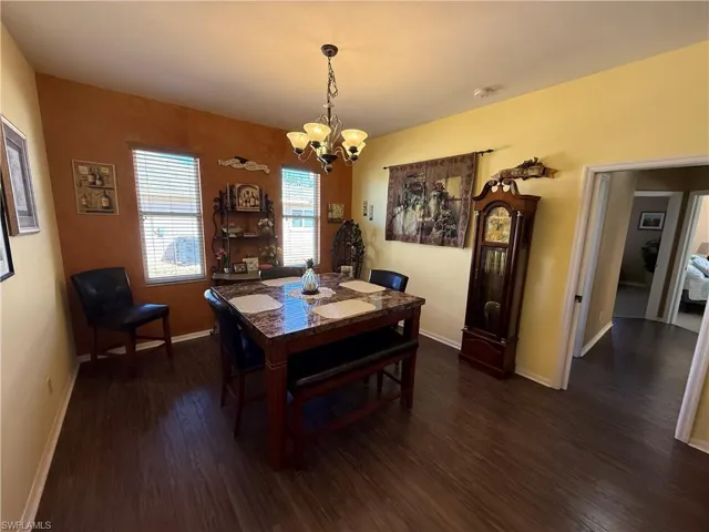Dining space with hanging lights and dark wood finished floors