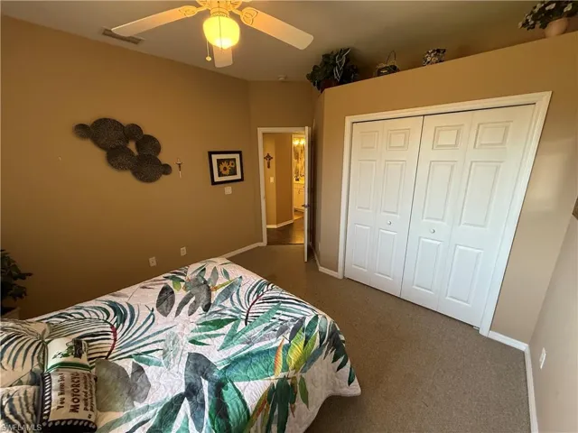 Bedroom with carpet flooring, a closet, and ceiling fan