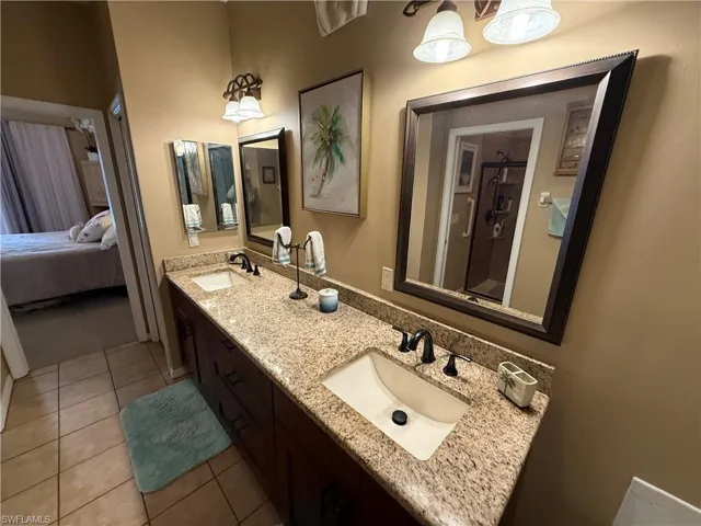 Ensuite bathroom with double vanity and light tile patterned floors