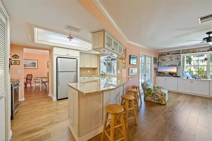 Kitchen with visible vents, ceiling fan, stainless steel electric range oven, a peninsula, and freestanding refrigerator