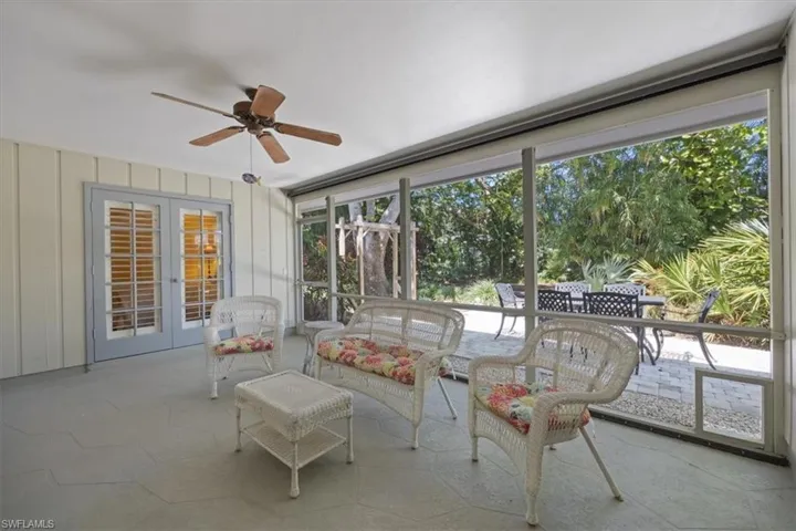 Unfurnished sunroom featuring french doors and ceiling fan