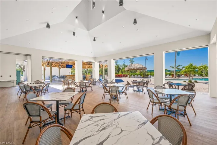 Dining space with light hardwood / wood-style flooring and high vaulted ceiling