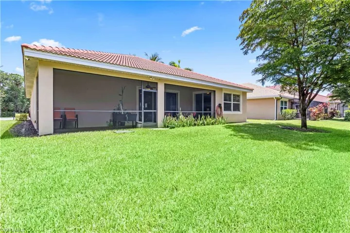 Back of property with a sunroom and a lawn