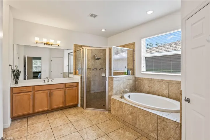 Bathroom featuring vanity, separate shower and tub, and tile patterned flooring