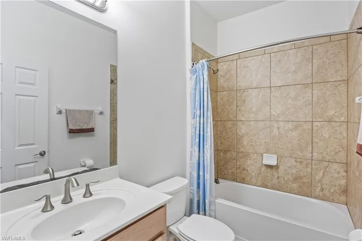 Full bathroom with vanity, toilet, and shower / tub combo with curtain
