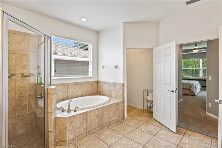 Bathroom featuring tile patterned flooring and separate shower and tub