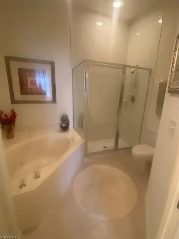 Full bathroom with a shower stall, a garden tub, toilet, and tile patterned floors