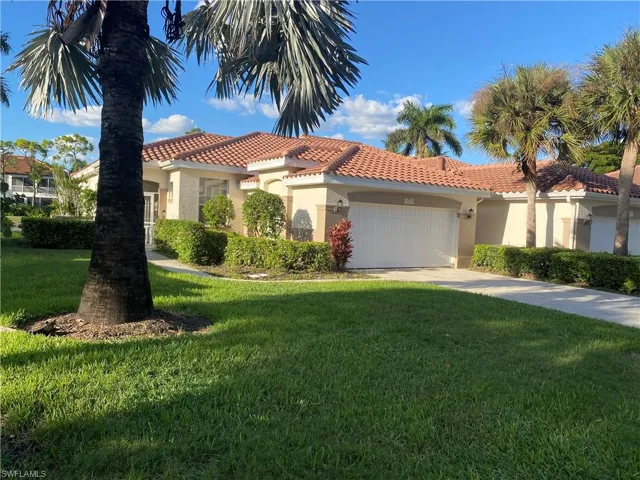Mediterranean / spanish-style house with stucco siding, a front lawn, a garage, a tile roof, and driveway
