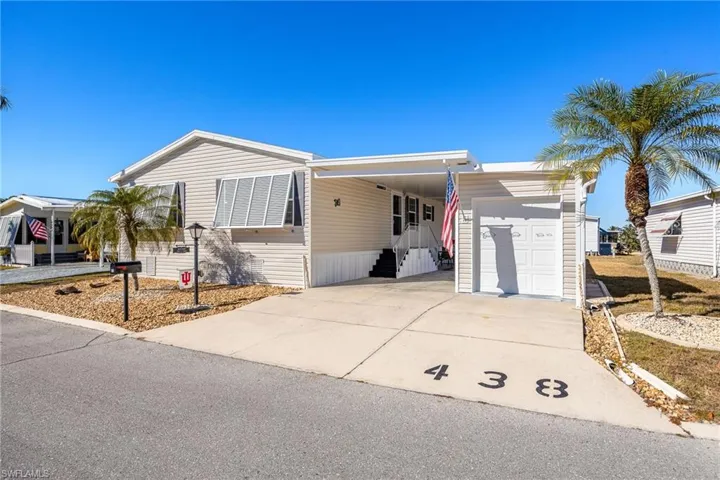 Manufactured / mobile home with concrete driveway, a carport, and covered porch
